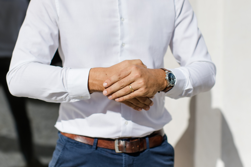 Joachim Metzler gibt seine Hände zusammen. Man sieht nur seinen Rumpf. An seinen Händen sind ein Ring und eine Uhr zu sehen.